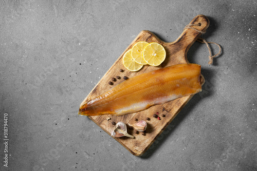 Fish muksun or whitefish cold smoked on a wooden Board. Smoked fish. Top view with space for text