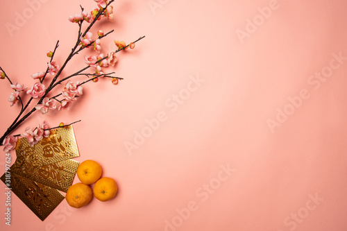 flat lay of mandarin orange and gold packet with chinese character 