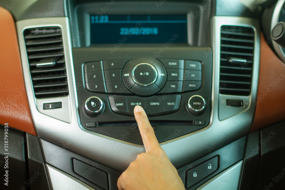 Obraz premium Asian Women press button on car radio for listening to music.