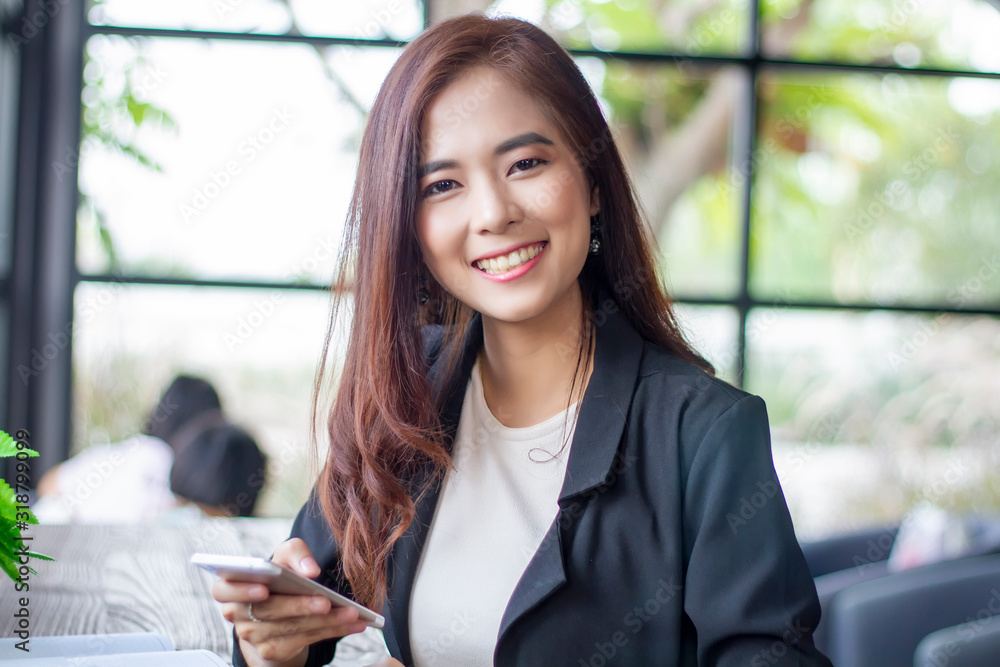 Asian business women using notebook and smart phone and business women smiling happy for working Asian business women using notebook and smart phone and business women smiling happy for working