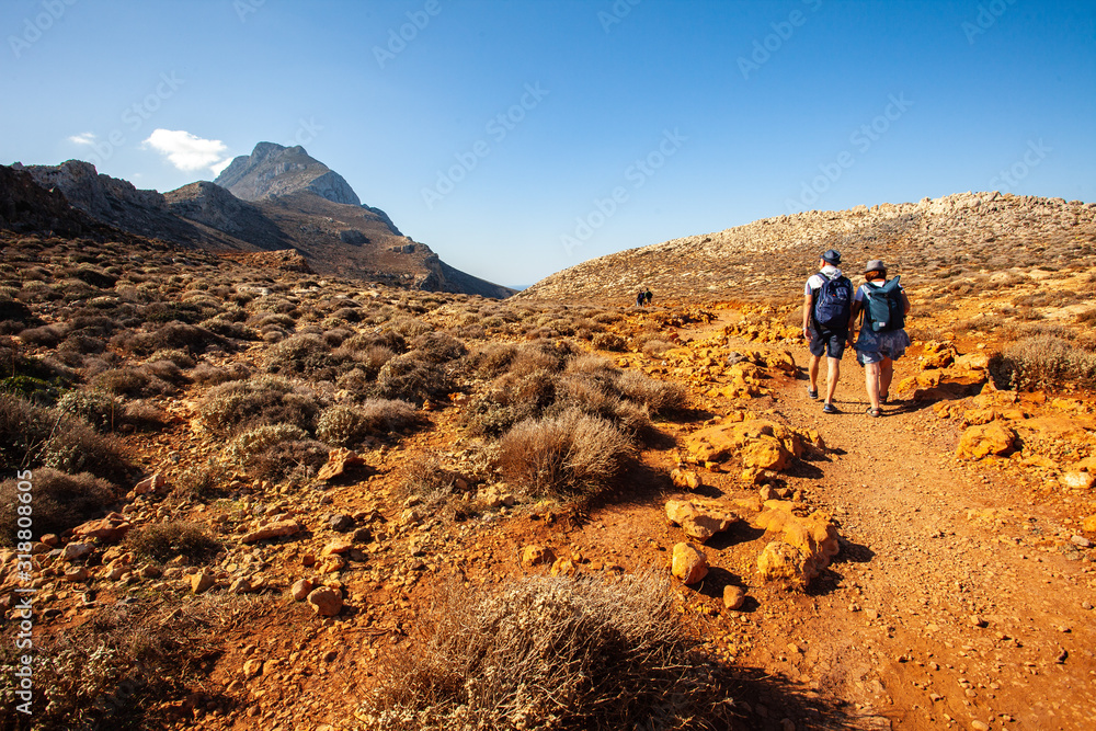 Balos lagoon on Crete island, Greece. Tourists relax and bath in crystal clear water of Balos beach. The most unique natural attraction in Crete.