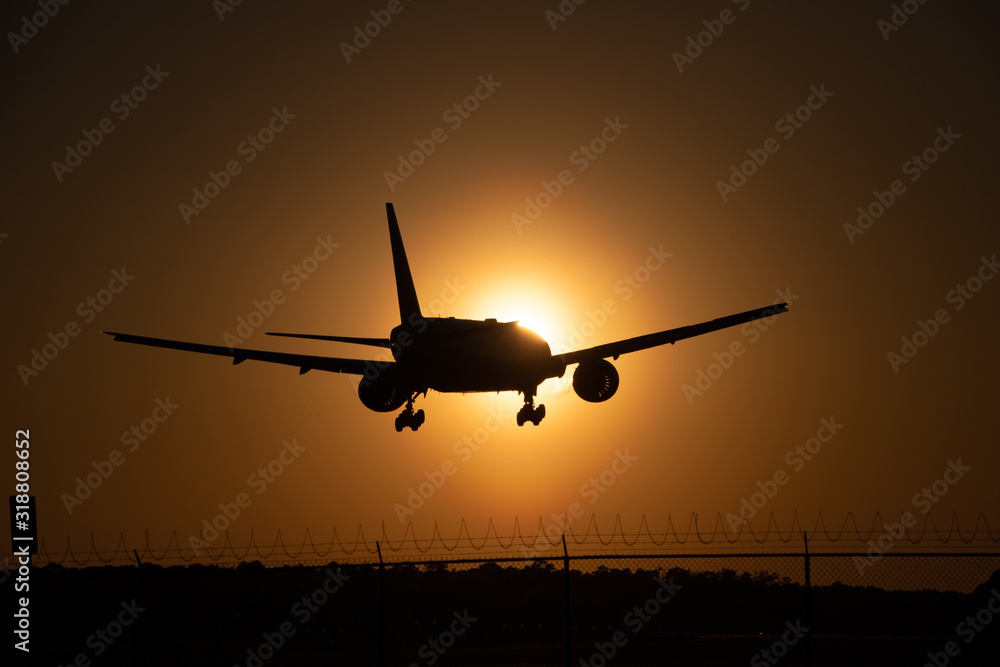 airplane landing into sunset