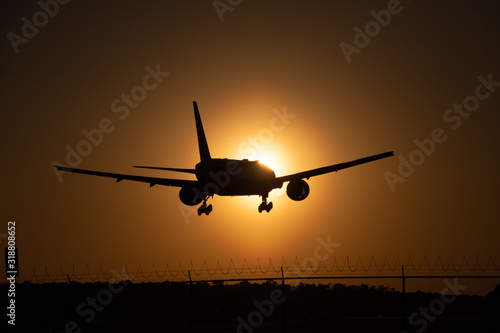 airplane landing into sunset