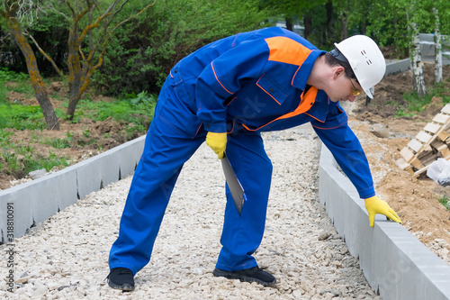 senior worker checks the completion of work on the construction of a pedestrian road