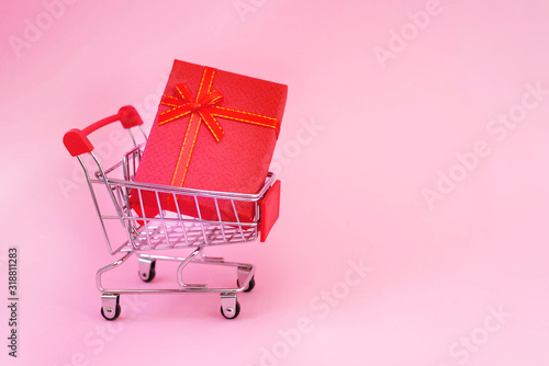 Happy Valentine's Day. Mini trolley from the supermarket, heart souvenir, 14, 2. Design for pink background, space for copying. Postcard, booklet. Discounts, sale. Black Friday!