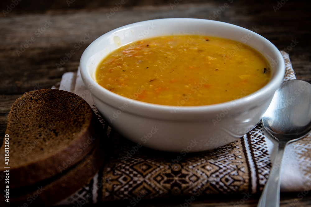 Pea soup in a white ceramic bowl on a kitchen napkin against the background of old wooden boards. Cooking homemade food. Pea soup in a white ceramic bowl on a kitchen napkin against the background of old wooden boards. Cooking homemade food.