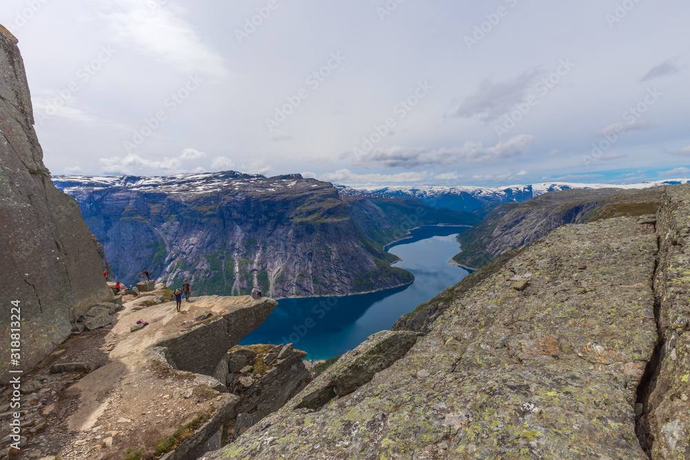Tourists On Trolltunga Taking Photos And Admiring The Fjord Scenery. 