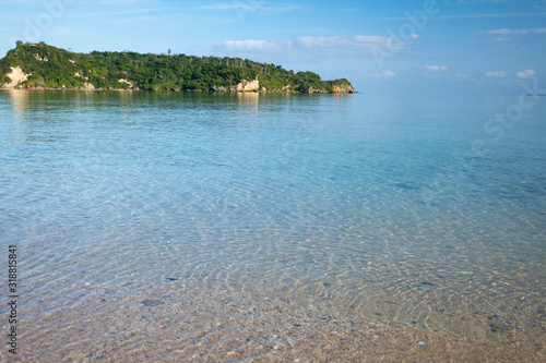 Fototapeta Naklejka Na Ścianę i Meble -  晴れた朝の屋我地島のビーチから眺める沖縄本島と透き通る静かな海の風景