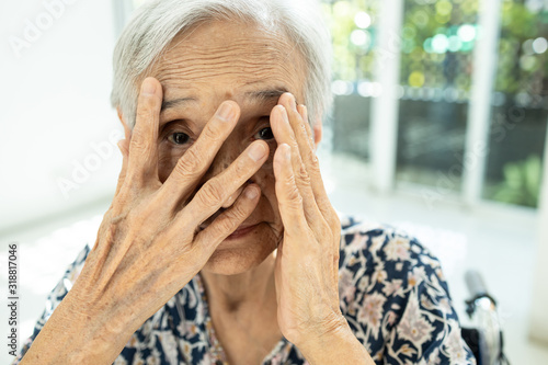 Fotografija Asian senior woman gazing through her fingers,terrified covering hiding her face