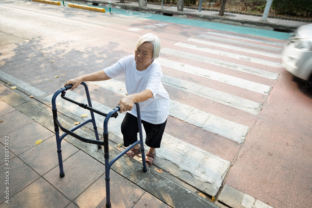 Asian senior woman was trying to walk up the sidewalk with walker after ...