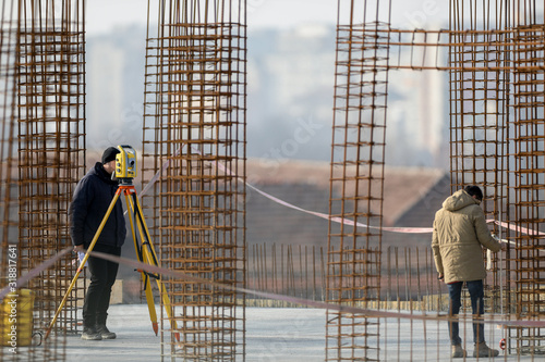 Men working with a leveling tool, on a construction site