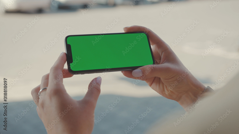 NEW YORK - May 19, 2019: Close up hands woman holding use phone horizontal green screen sitting on street scrolling pages swiping surfing internet technology smartphone message mobile phone slow NEW YORK - May 19, 2019: Close up hands woman holding use phone horizontal green screen sitting on street scrolling pages swiping surfing internet technology smartphone message mobile phone slow