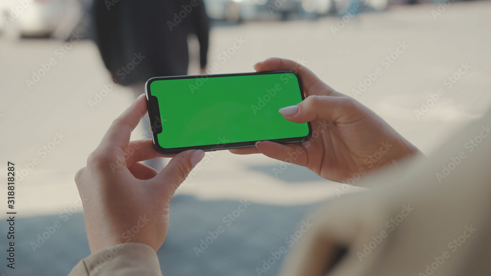 NEW YORK - May 19, 2019: Close up hands woman holding use phone horizontal green screen sitting on street scrolling pages swiping surfing internet technology smartphone message mobile phone slow NEW YORK - May 19, 2019: Close up hands woman holding use phone horizontal green screen sitting on street scrolling pages swiping surfing internet technology smartphone message mobile phone slow