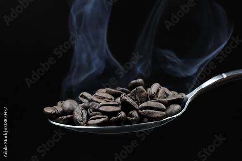 coffee beans in a scoop dark background