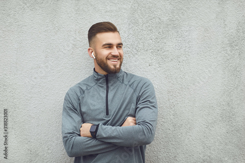 Bearded guy in sportswear on gray background.