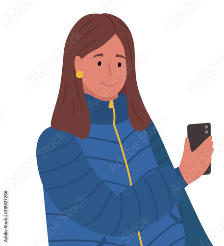 Brunette woman standing and messaging on phone. Person hold smartphone in hand. Lady dressed in warm cloth, blue overcoat. Adult isolated on white background. Vector illustration in flat style