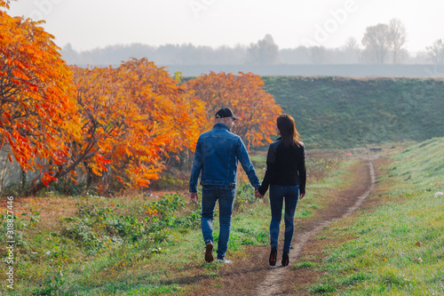 Loving couple walks in the autumn along the alley. © combo1982