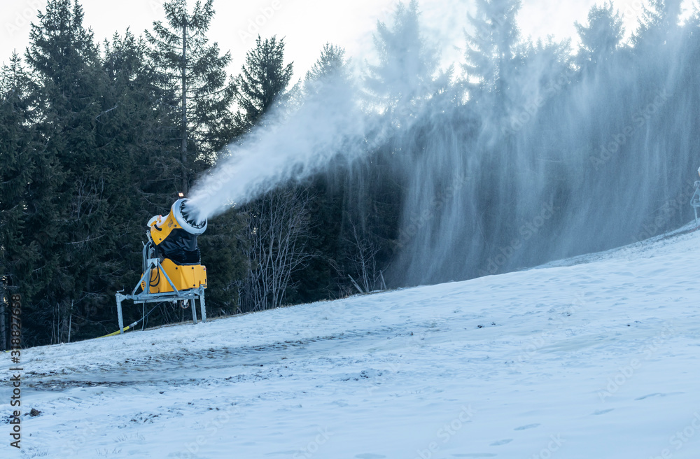 Skipiste mit Schneekanone für Kunstschnee in betrieb Skipiste mit Schneekanone für Kunstschnee in betrieb