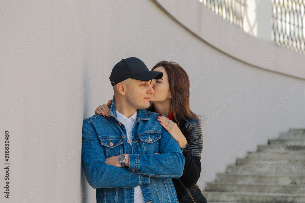 Happy lovers hug on a concrete staircase.