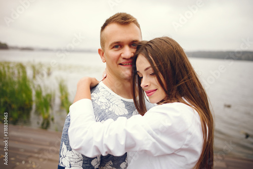 Cute couple walking near water. Girl in a white shirt. Pair by the river