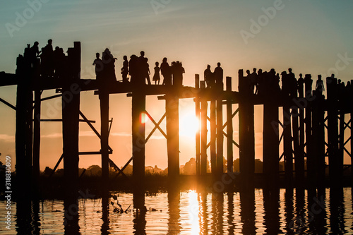 Silhouette of people walking on Bridge U-Bein at sunset scene in Amarapura, Mandalay, Myanmar