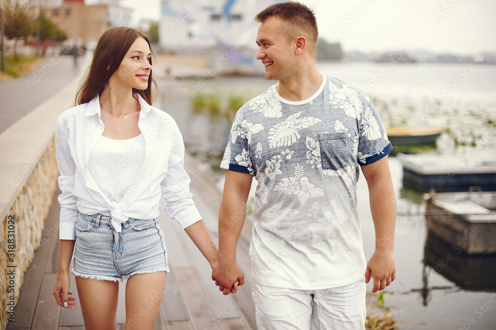 Cute couple walking near water. Girl in a white shirt. Pair by the river