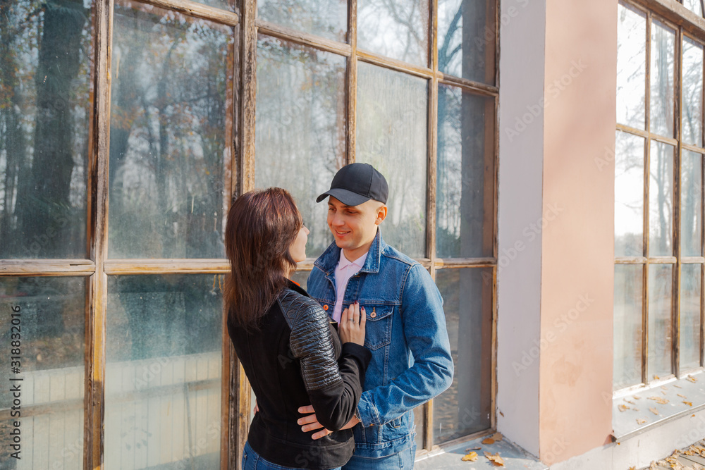 Happy lovers by the window in the park in autumn weather. Happy lovers by the window in the park in autumn weather.