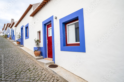 Cobblestone street with blue and white traditional colorful homes and buildings in the Algarve town of Odeceixe photo
