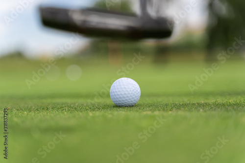 Golf ball and golf club in motion on a golf course