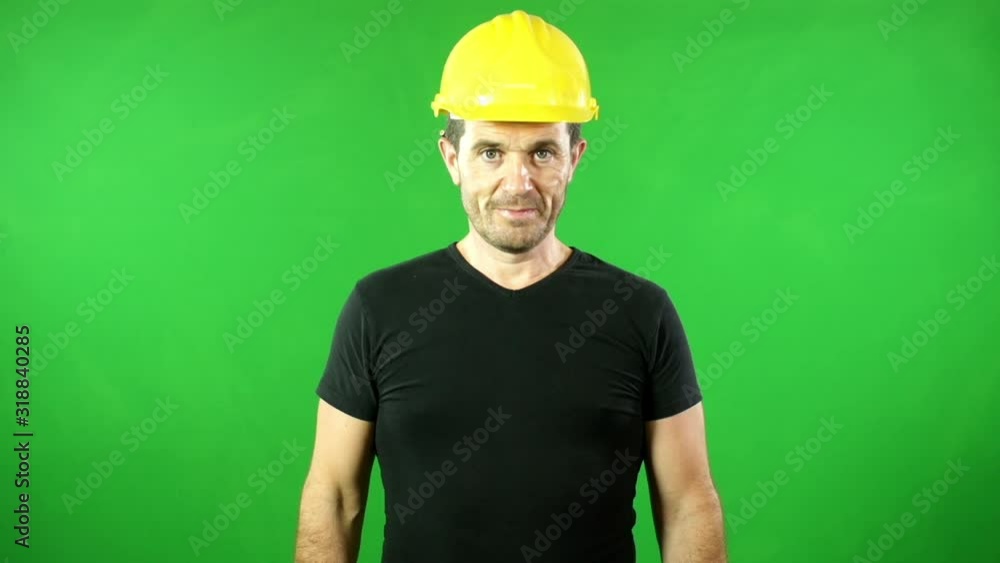 Tradesman / Handyman / Builder in front of a Green Screen. Chroma key. The man is Smiling and looking at the camera Tradesman / Handyman / Builder in front of a Green Screen. Chroma key. The man is Smiling and looking at the camera