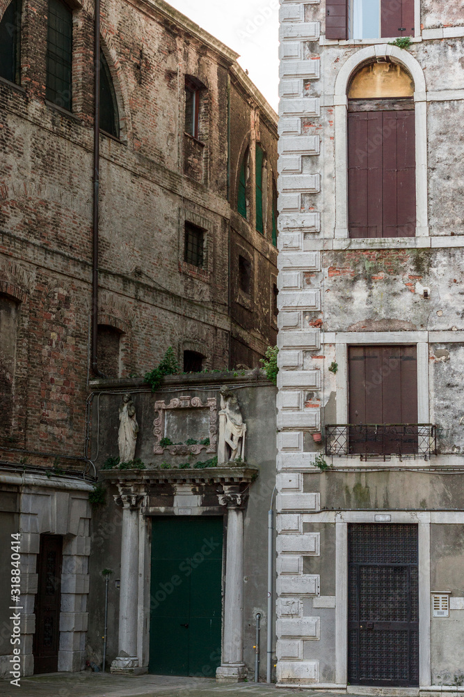 Walls and windows of old buildings in street of Venice 