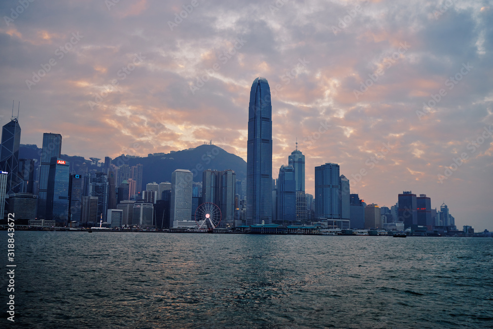 Hong Kong skyline cityscape downtown skyscrapers over Victoria Harbour at sunset time. Hong Kong, China.
