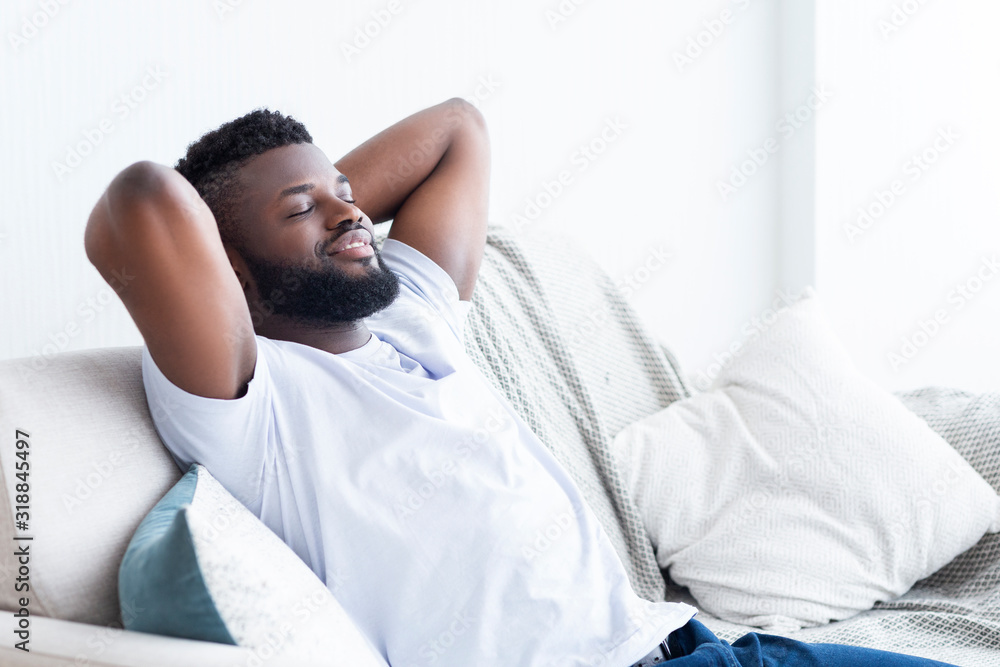 Relaxed african american man resting at home on sofa Relaxed african american man resting at home on sofa