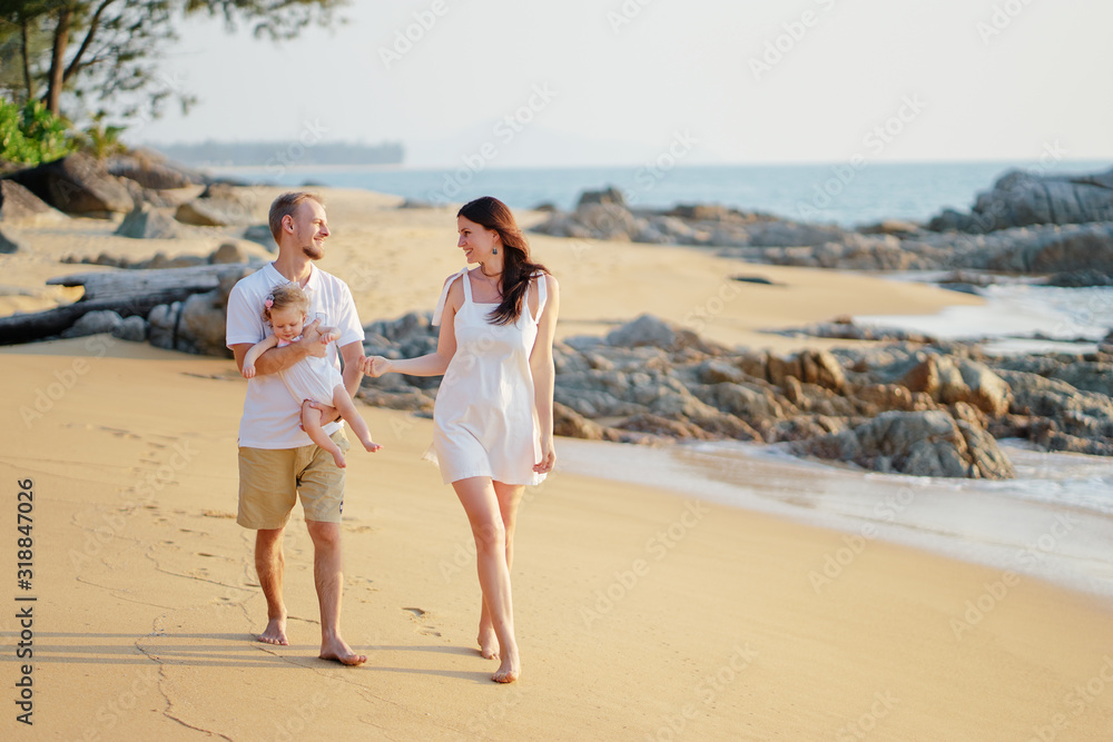 Vacation near the sea. Family with little kid walking on the beach. Vacation near the sea. Family with little kid walking on the beach.