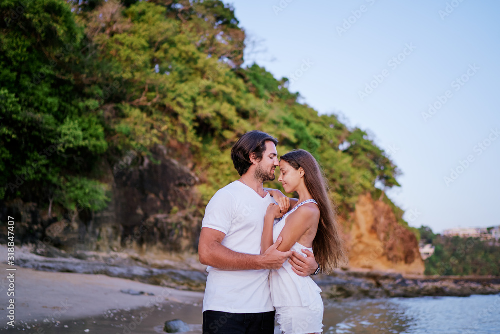 Love and romance. Honeymoon on the sea shore. Happy loving couple embracing on the beach.