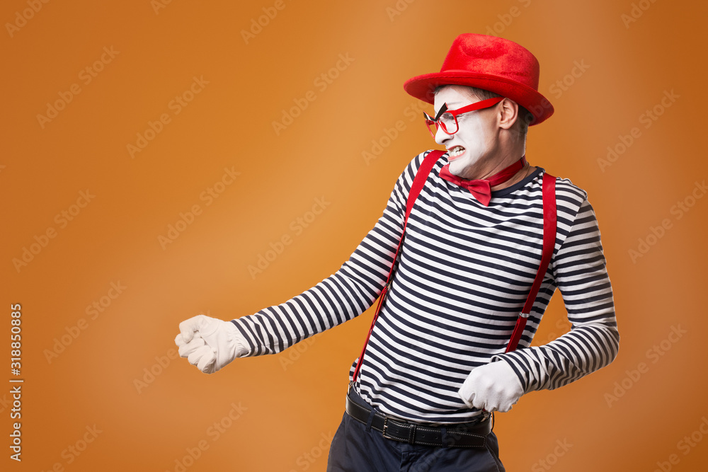 Dissatisfied mime man in vest and red hat on orange background Dissatisfied mime man in vest and red hat on orange background