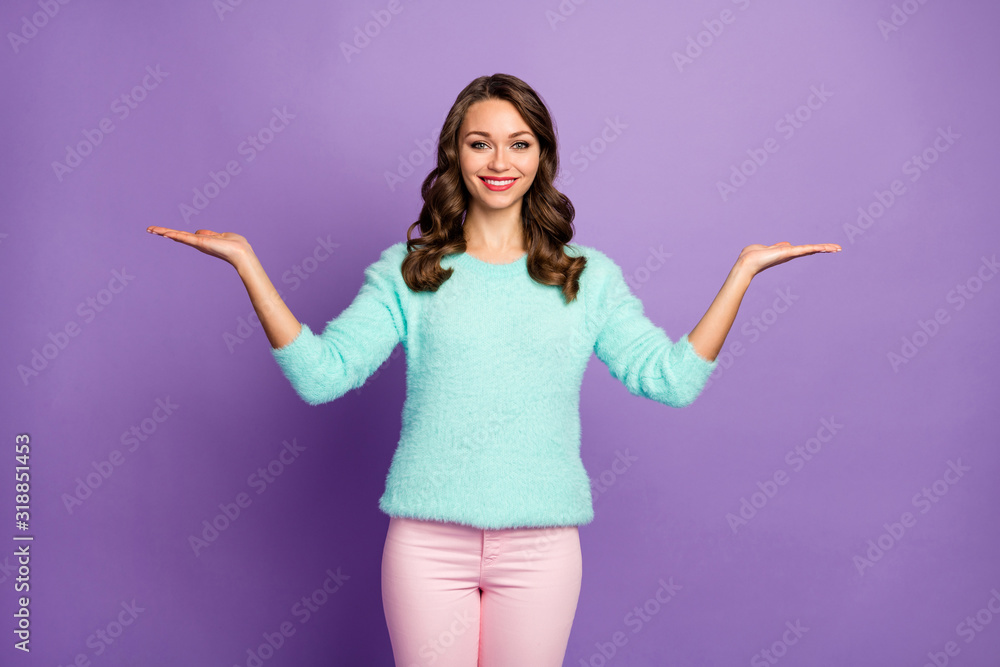 Photo of beautiful curly lady holding open arms advising black friday low shopping prices novelty products wear casual teal fluffy pullover pink pastel pants isolated purple color background