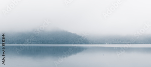 Panoramic view of a mountain lake in the foggy weather