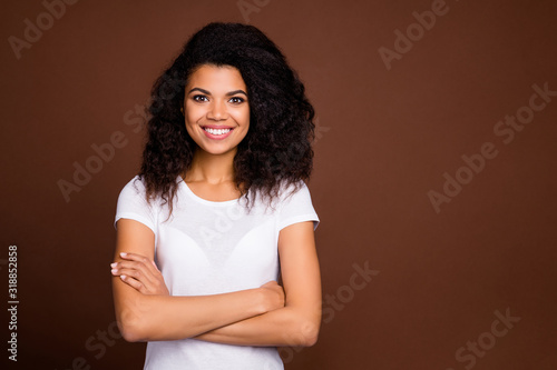 Portrait of content charming afro american girl cross hands good look feel success emotion wear casual style clothes isolated over brown color background © deagreez