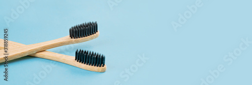 Two bamboo toothbrushes on bluw background. Eco friendly lifestyle