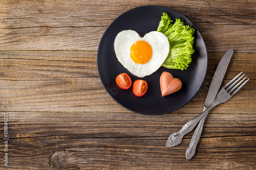 Valentines day breakfast with heart shaped fried eggs served on grey plate. photo