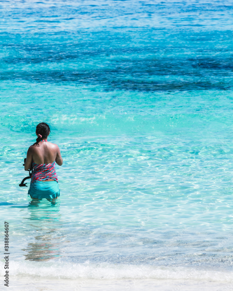 Female tourists in bikinis stand on the sea At Similan Island, Phang Nga, Thailand