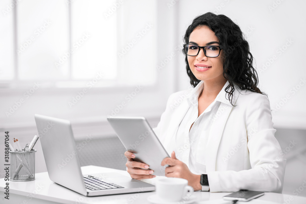 Portrait of mexican saleswoman using tablet and computer Portrait of mexican saleswoman using tablet and computer