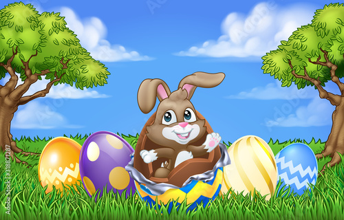 The Easter bunny rabbit breaking out of a chocolate Easter egg in an outdoor scene