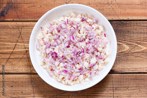 Step-by-step preparation of Tiffany puff salad, step 1 - first and second layer - boiled chicken fillet and chopped salad onions, top view, selective focus