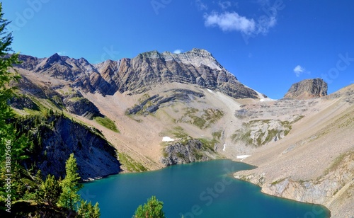 Beautiful blue Hamilton Lake high in the mountains. Rocky mountains, steep shore, pine trees. Blue sky, sunny day. Canada.