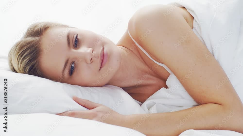 Young woman in the bed. Beautiful blond girl wakes up. Morning in the bedroom, daylight from the window. Health and rest. Young woman in the bed. Beautiful blond girl wakes up. Morning in the bedroom, daylight from the window. Health and rest.