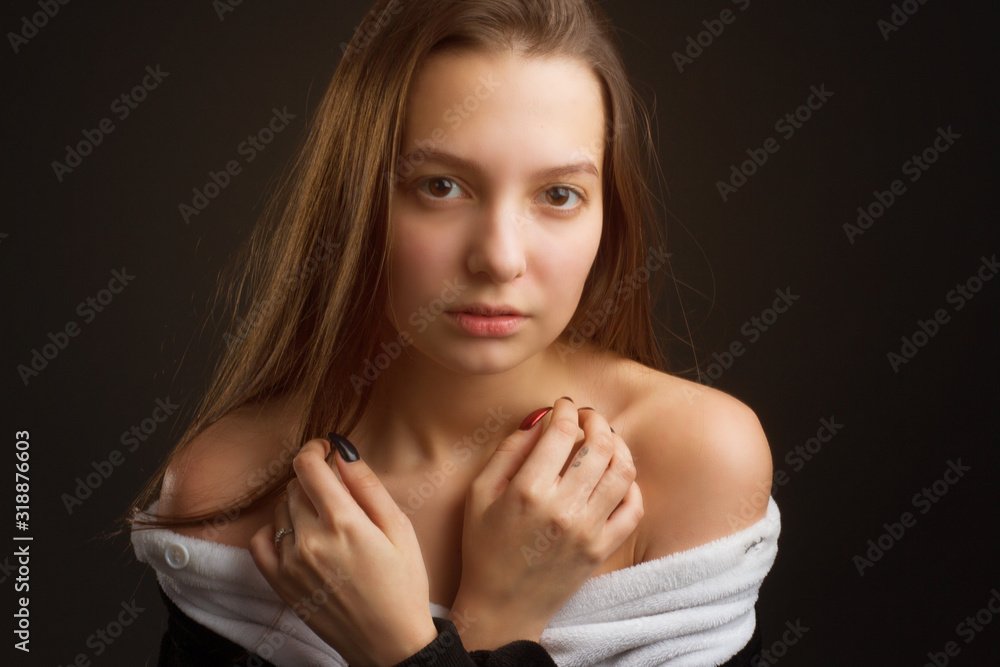 portrait of a brunette girl in the Studio on a plain black background in black and white pajamas with a hood portrait of a brunette girl in the Studio on a plain black background in black and white pajamas with a hood