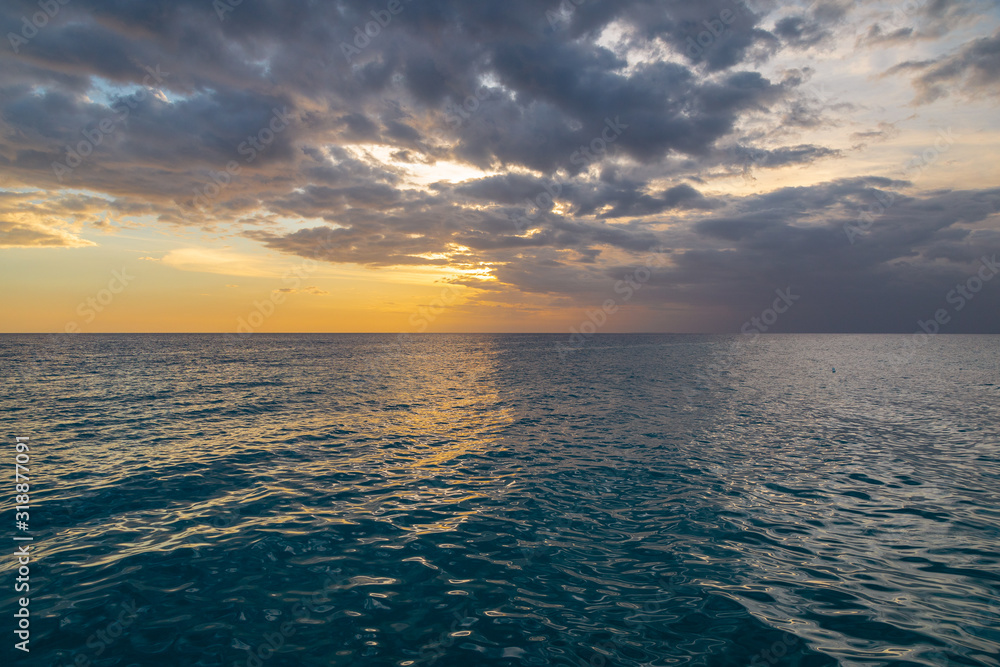 Beautiful sunset on the Caribbean, bright orange sun in the clouds.