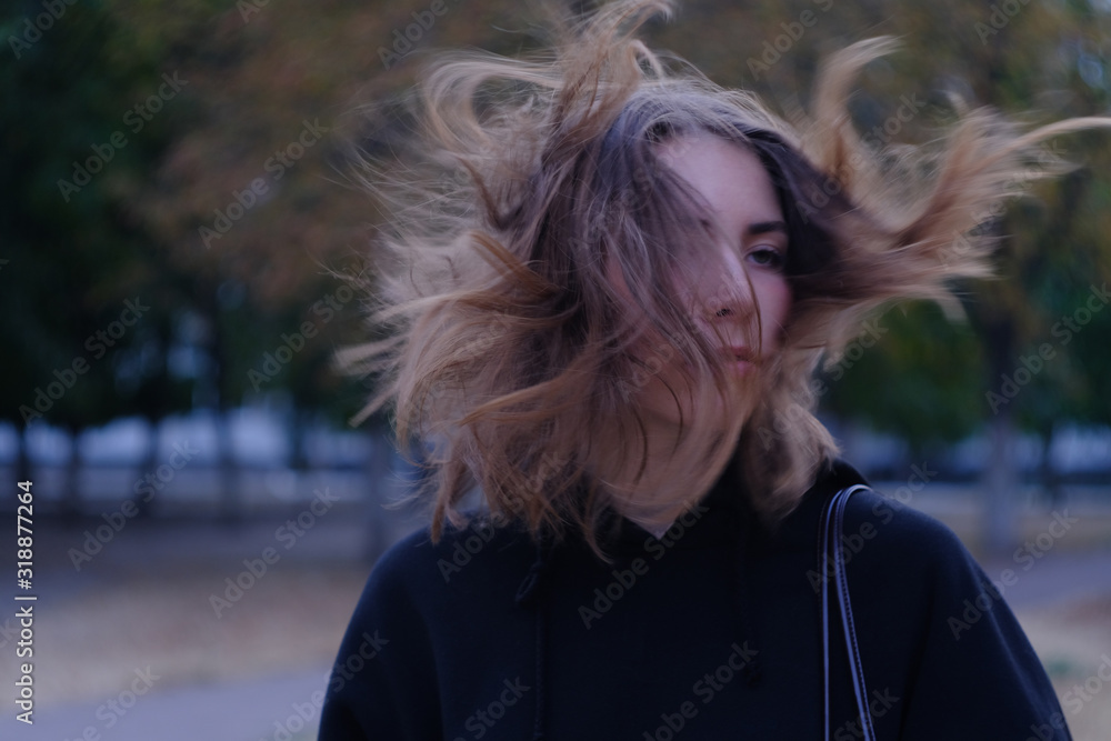 Serious look of girl with windy hair at dark street Serious look of girl with windy hair at dark street
